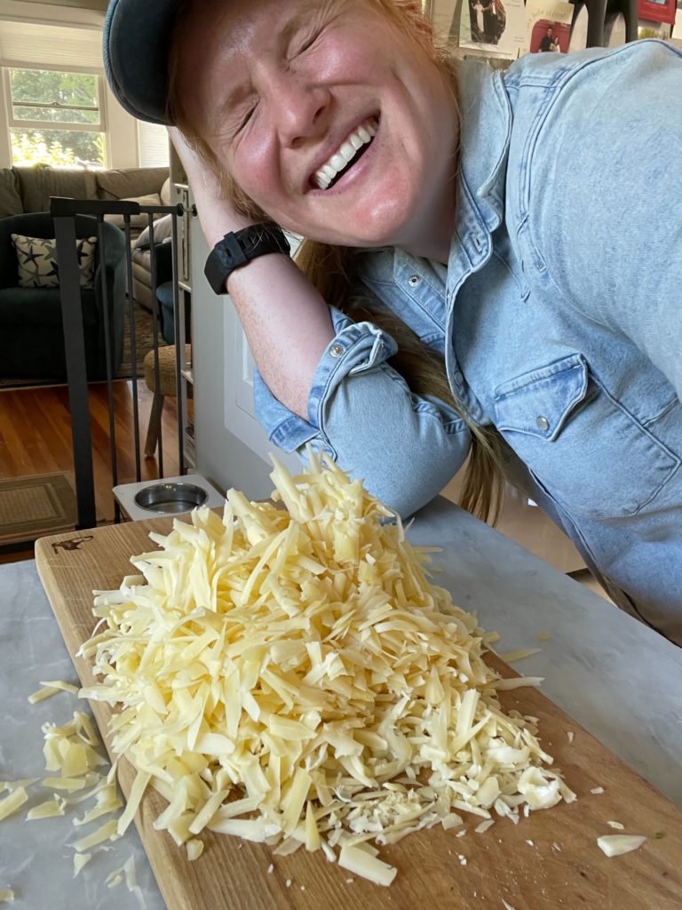 Morgen, laughing, with a mound of shredded Jarlsberg cheese