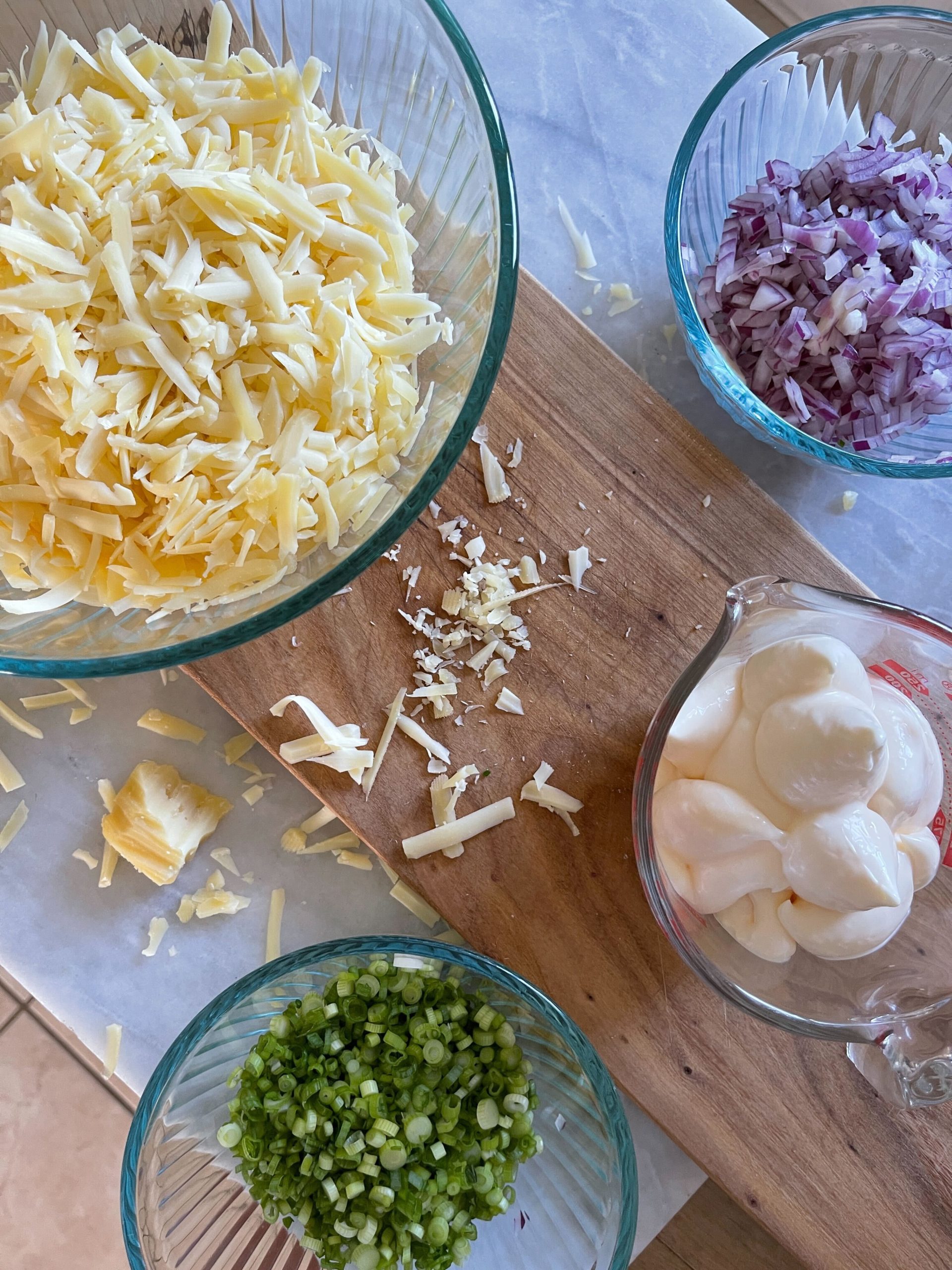 Jarlsberg Cheese Dip ingredients - chopped green onion, diced red onion, mayo, and shredded Jarlsberg cheese