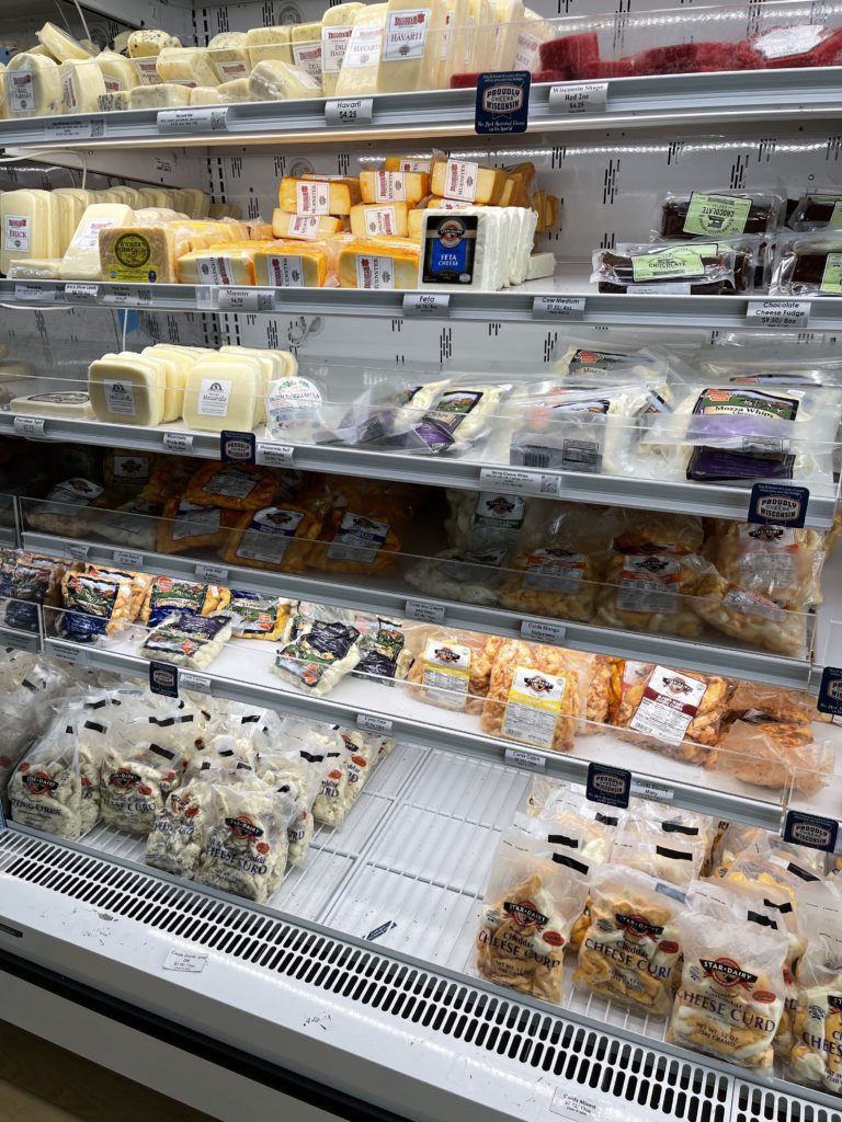A look at the cheeses on the shelves at The refrigerators at Wisconsin Cheese Mart