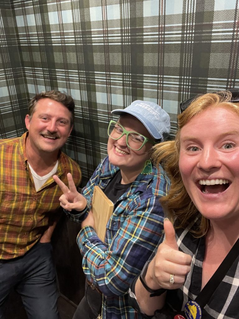 Alex, Carrie, and Morgen in plaid shirts, in a plaid elevator