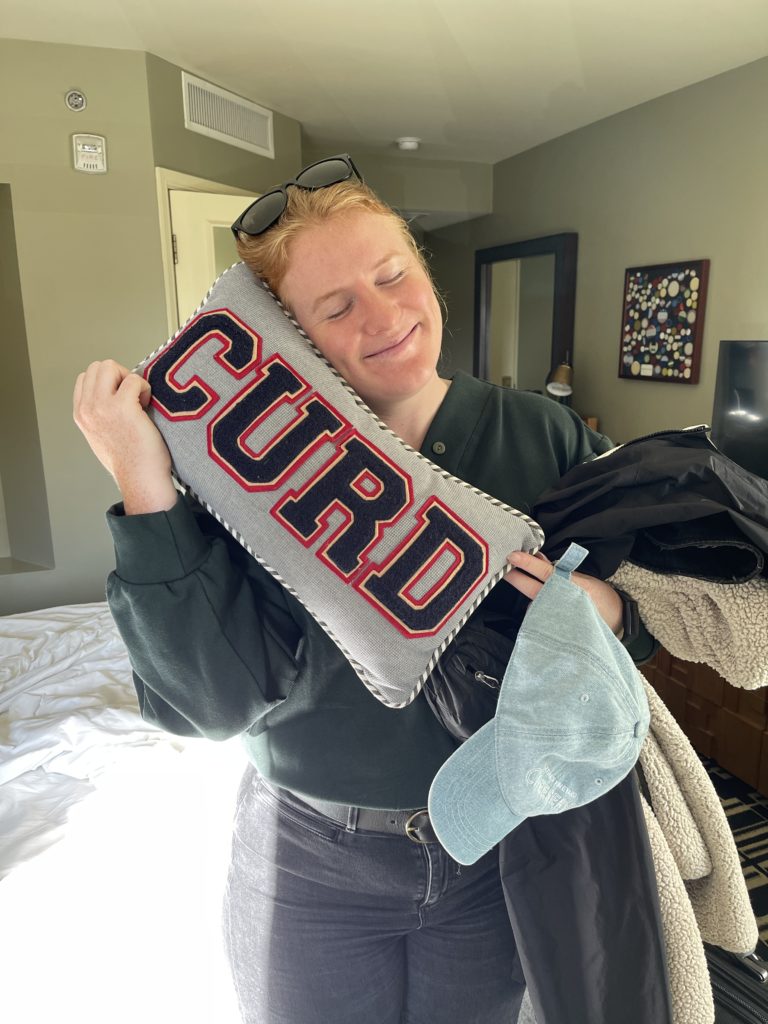 Morgen hugging a decorative throw pillow that says "CURD" at the Graduate Madison Hotel