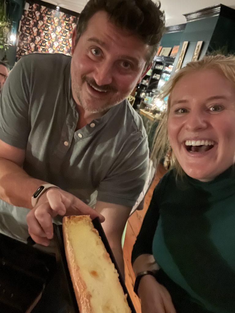 Morgen and Alex are all smiles, posing with the raclette wheel after a successful evening!