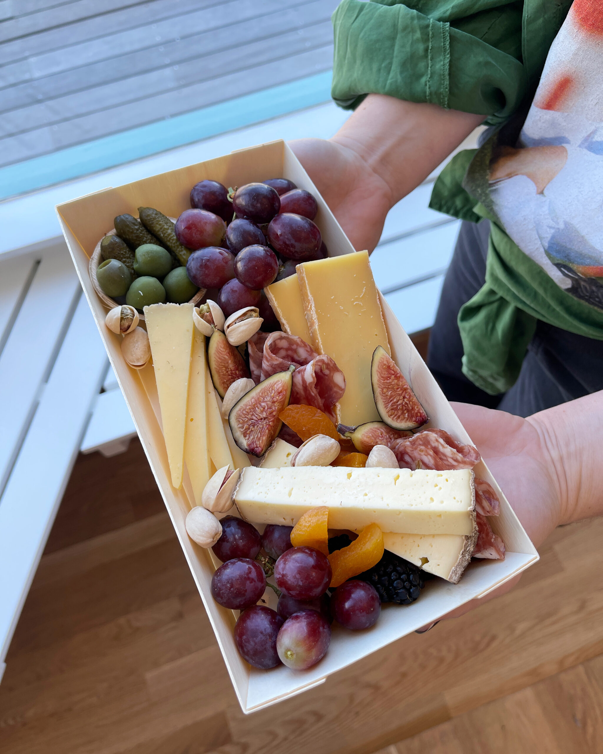 A photo of the Personal Grazing Box from Martha's Vineyard Cheesery. Three types of cheese, one charcuterie, fresh and dried fruit, pickles, olives, and nuts. Over 6oz of cheese, plus all the accompaniments!